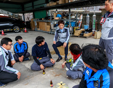 シンカ（SINKA）株式会社　大牟田営業所で若手社員と車座で雑談する八谷 博之社長